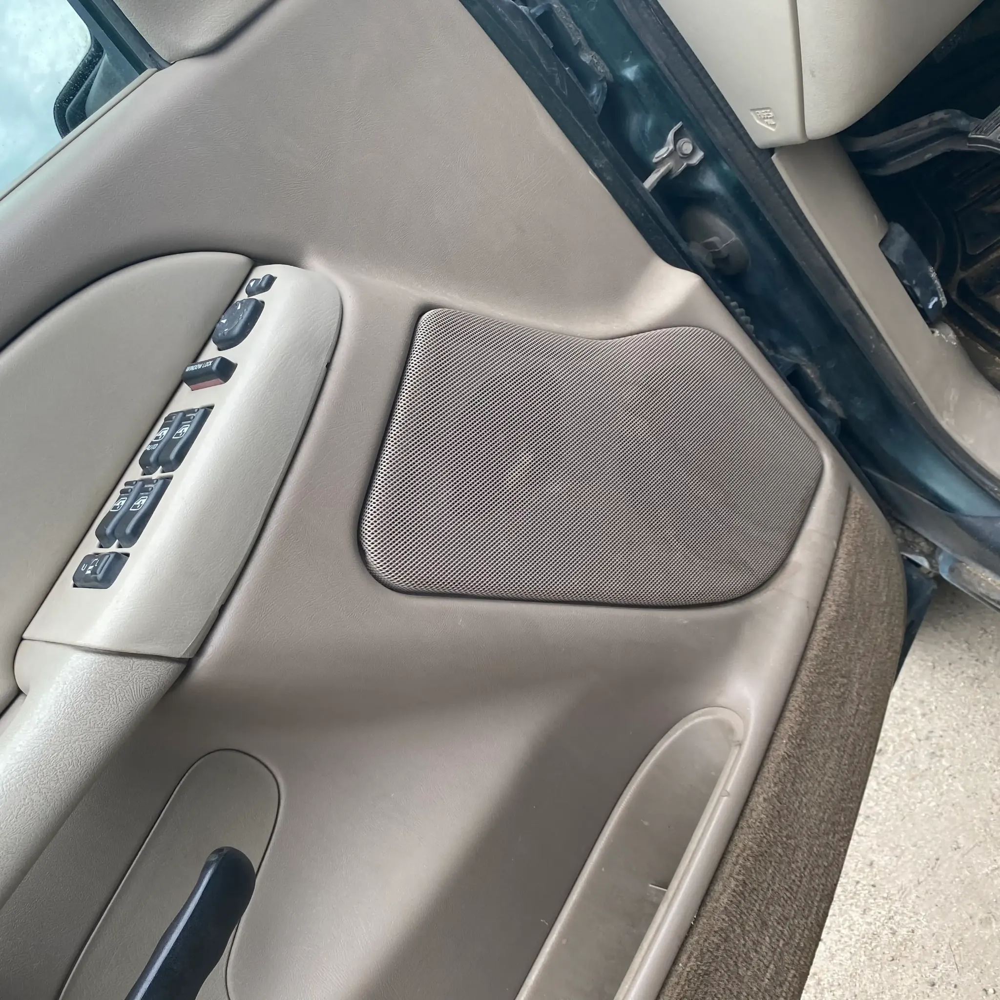 Factory door speaker grille in a vehicle door panel